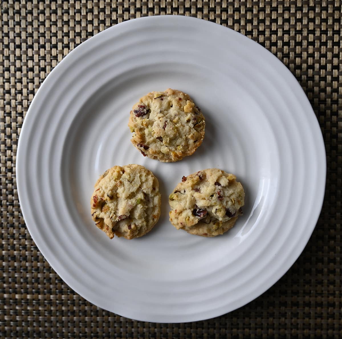 Top down image of three cookies served on a white plate. 