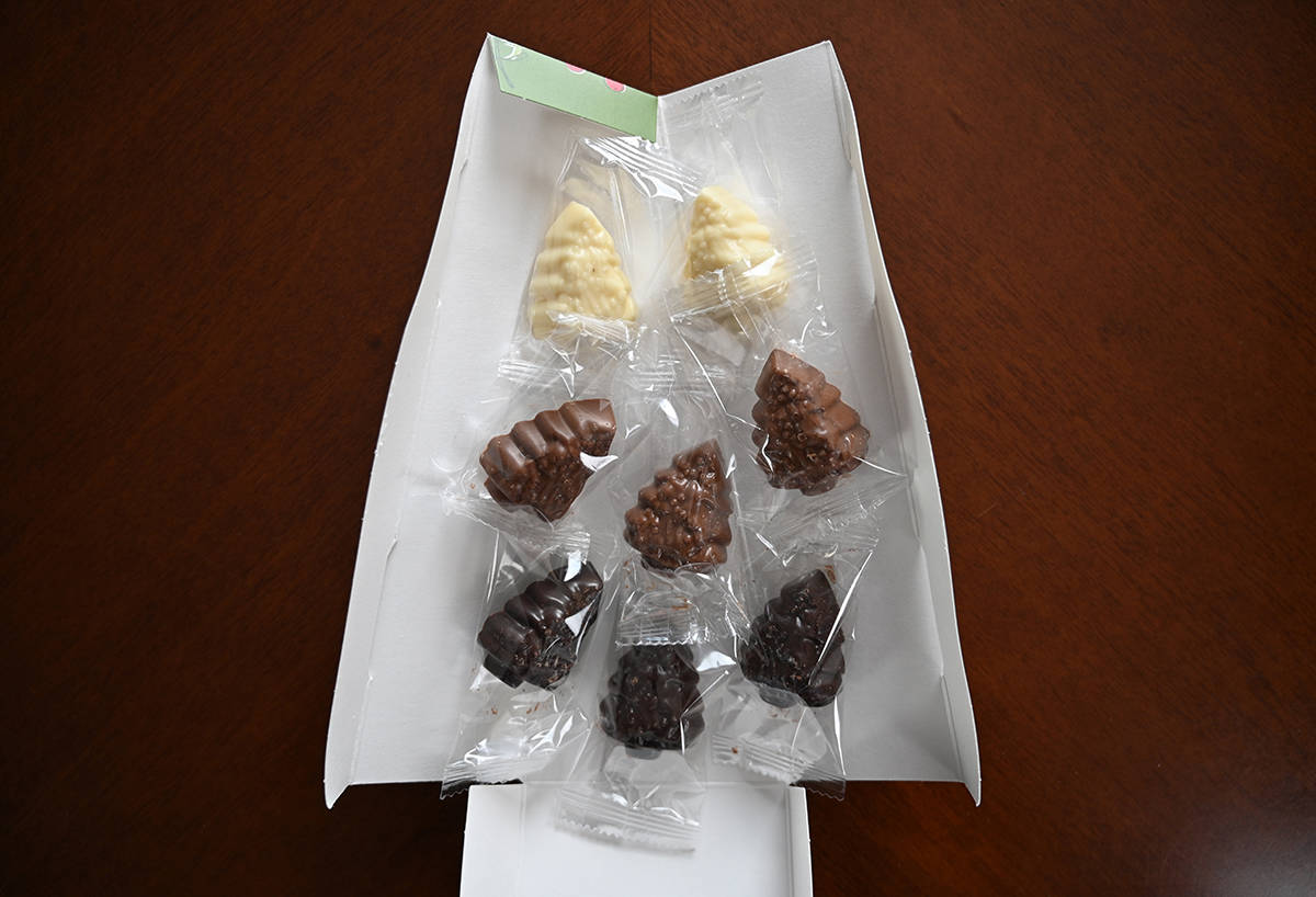 Image of one of the small gift boxes of chocolates that comes in the larger box opened showing eight individually wrapped chocolates in the box.