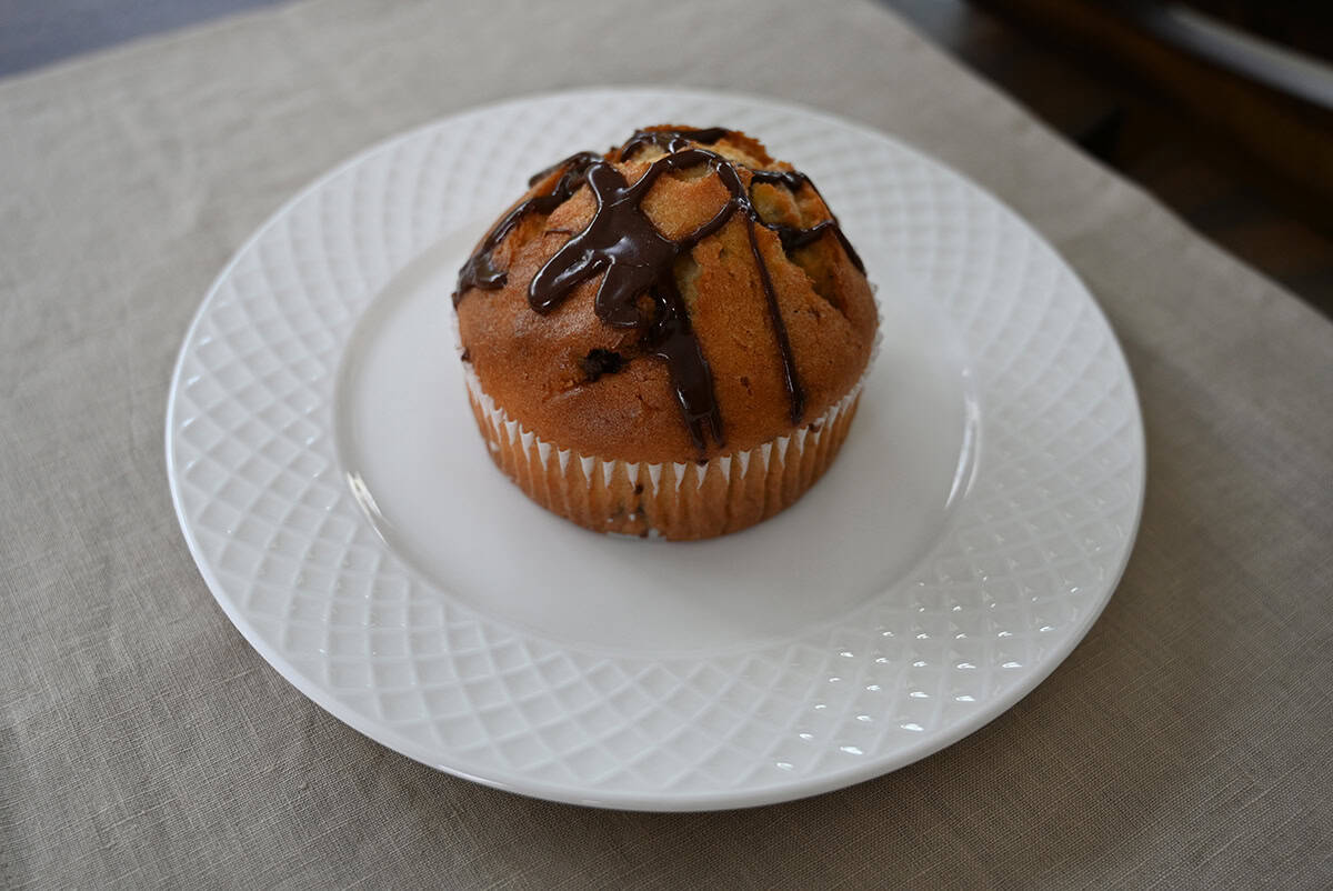 Top down image of one Costco Vanilla Chocolate Chunk Muffin served on a white plate.