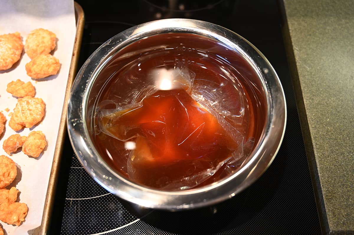 Image of a packet of sauce sitting in a bowl of warm water 