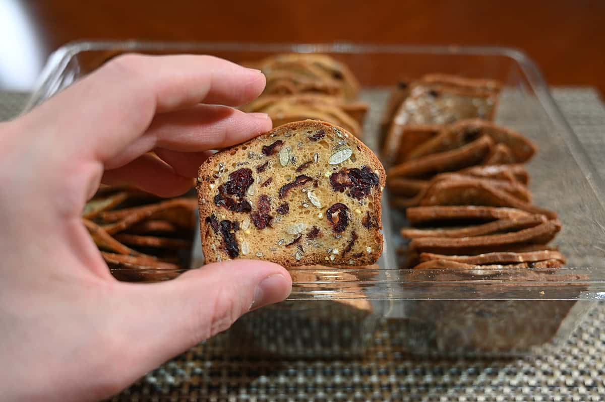 Image of a hand holding a cranberryliscious cracker close to the camera.