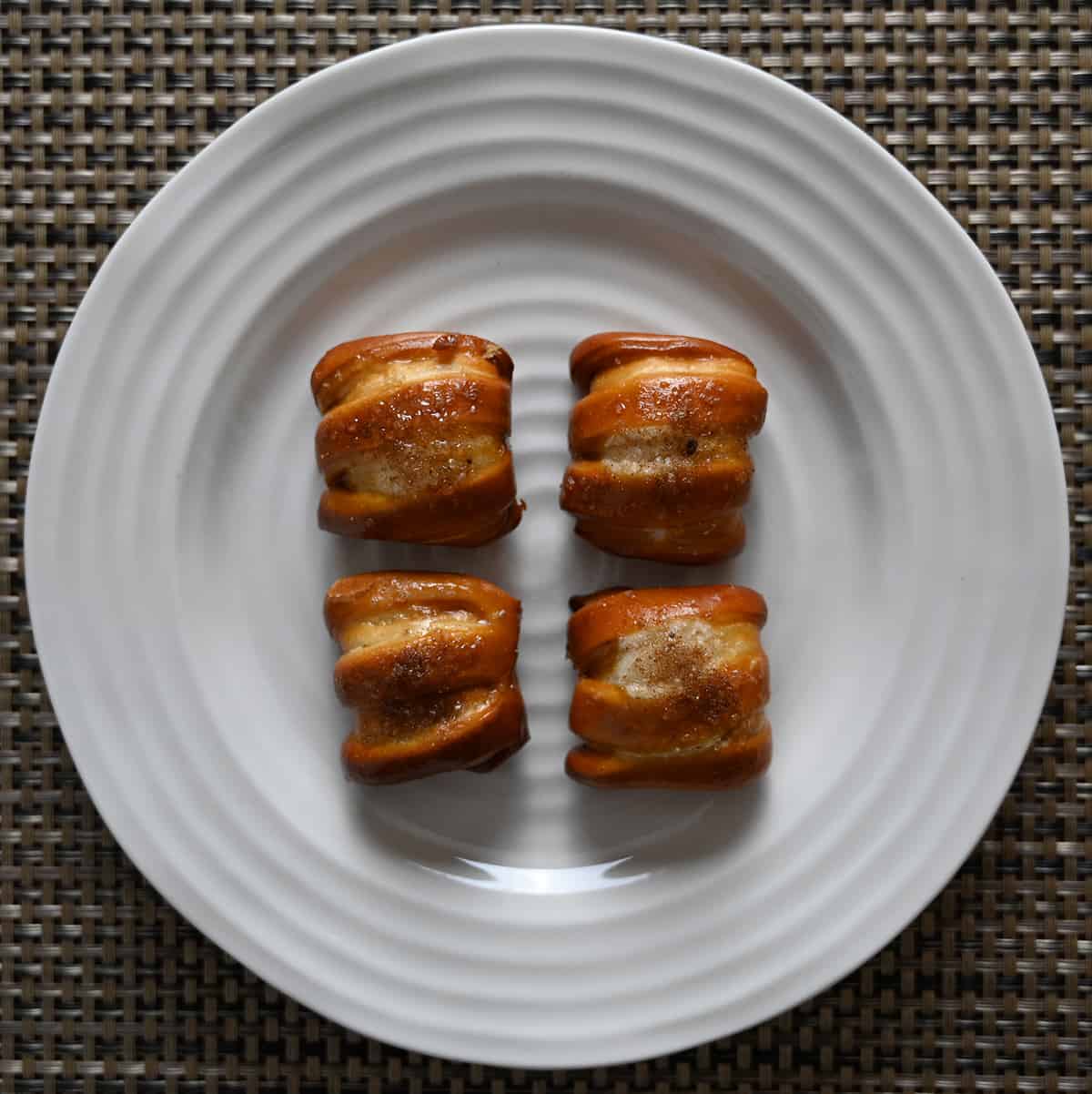 Top down image of four one-timer bites pretzels baked and served on a white plate.