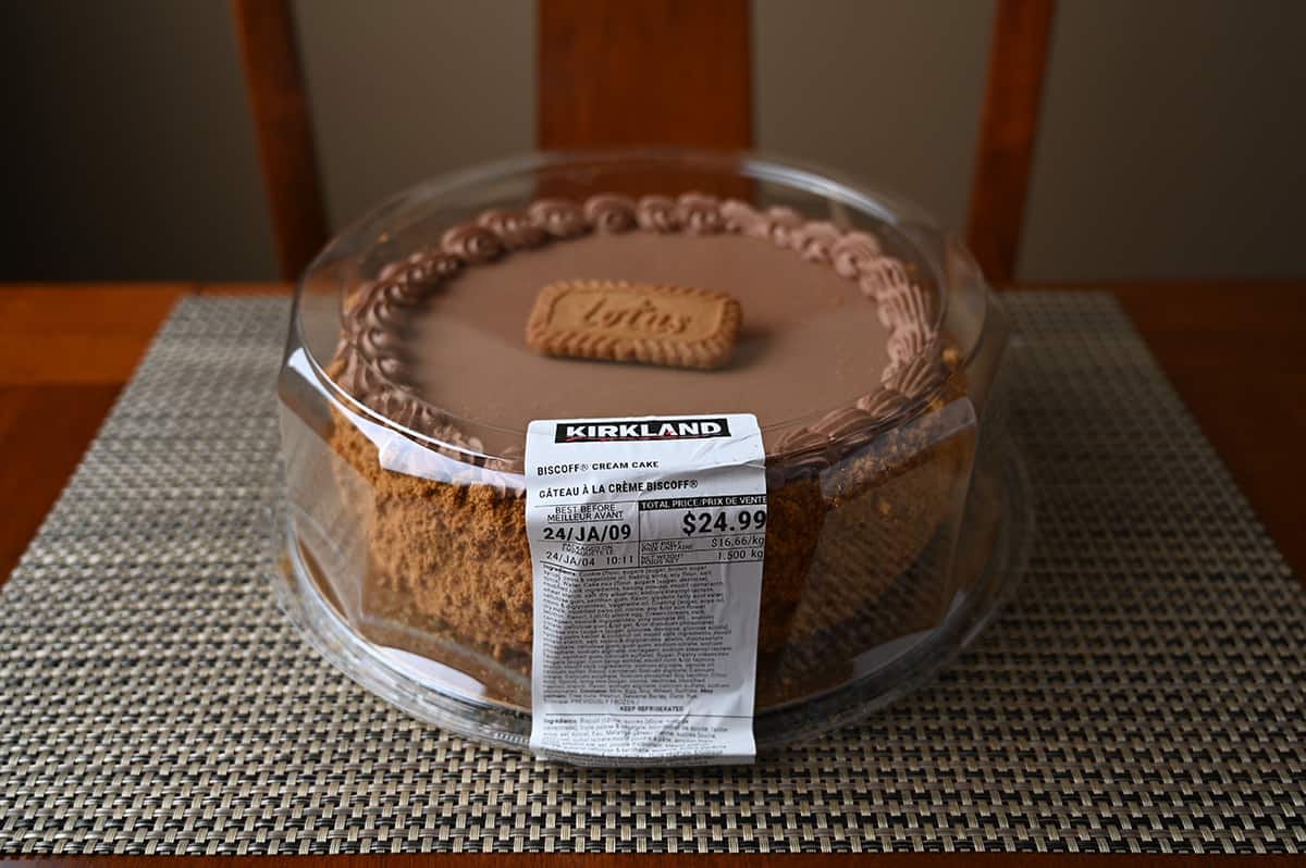 Sideview image of the Kirkland Signature Biscoff Cream Cake from Costco in the packaging sitting on a table.