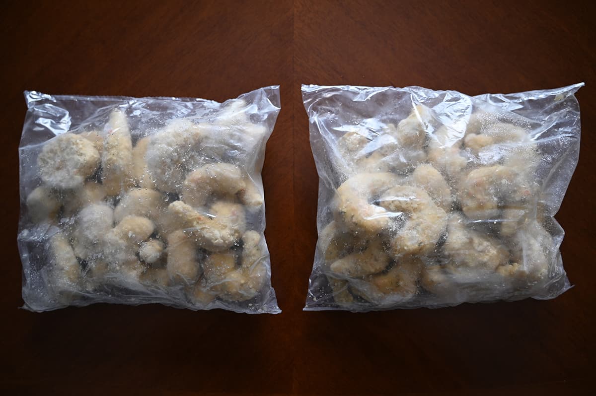 Top down image of two bags of frozen shrimp unopened sitting on a table.