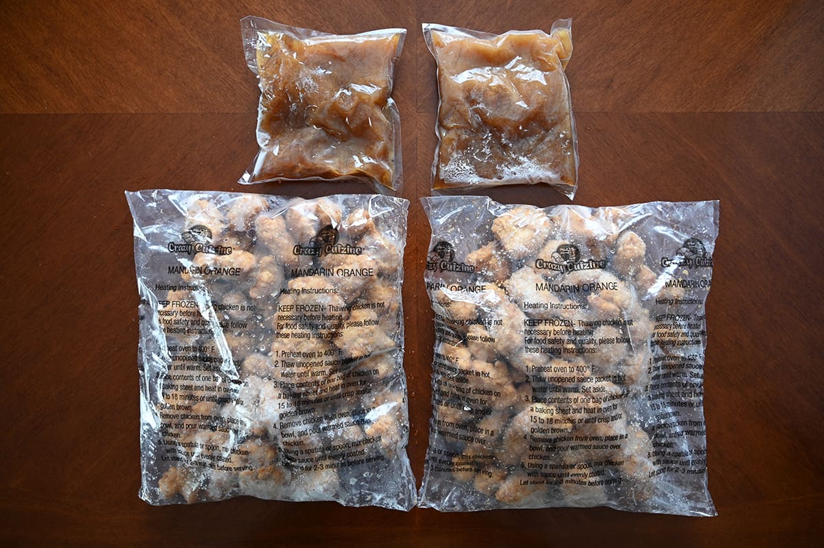 Top down image of two bags of  frozen chicken pieces beside two bags of sauce unopened.