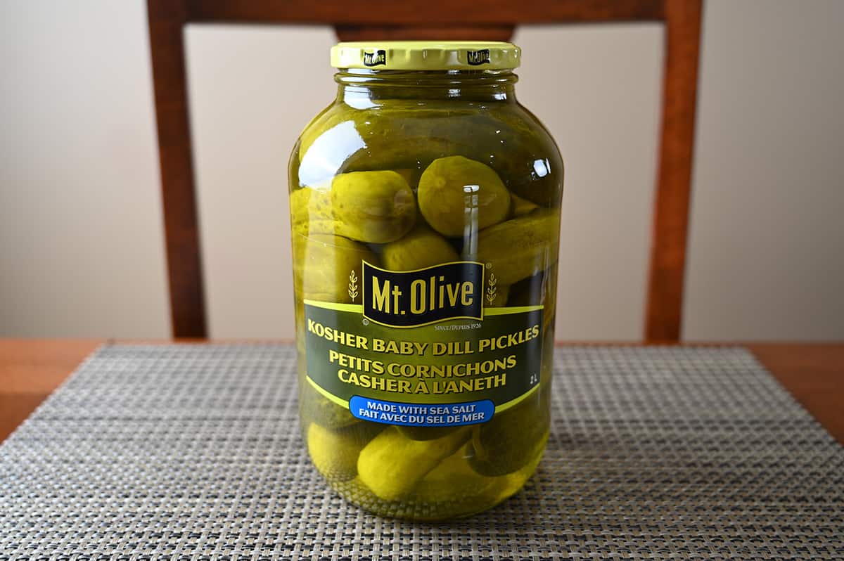 Image of the Costco Mt. Olive Kosher Baby Dill Pickles jar sitting on a table unopened.