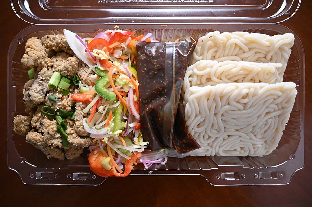 Top down image of an open container of ginger beef stir-fry showing all the contents in the container prior to cooking.