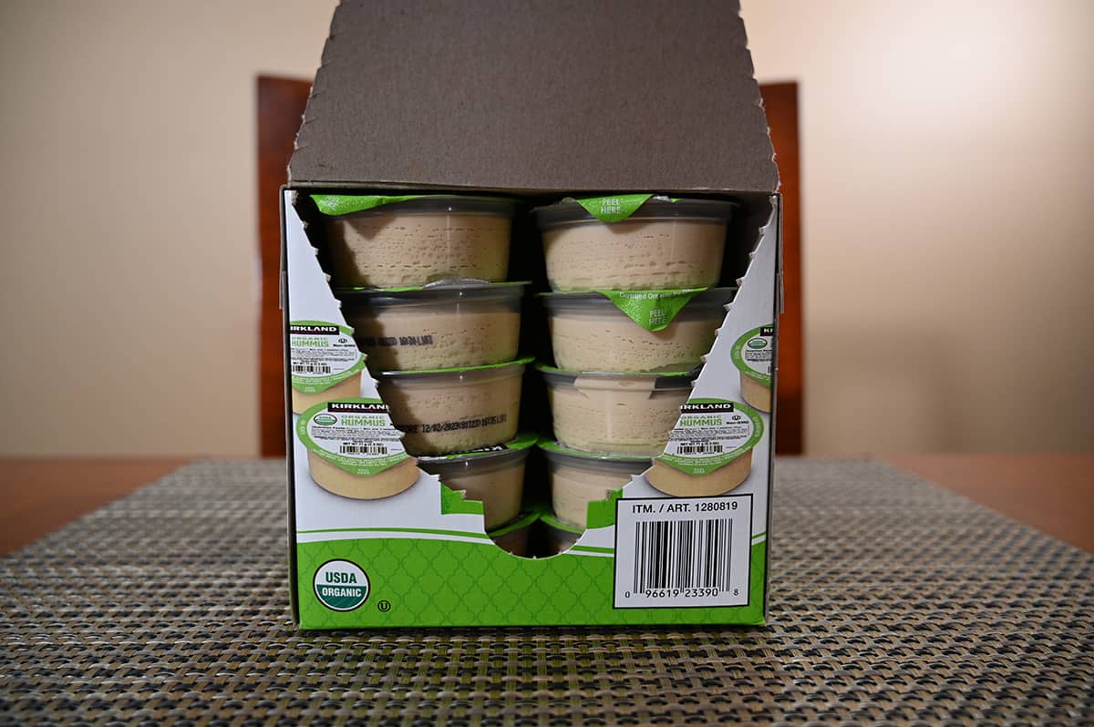 Sideview image of a box of individually packaged hummus cups opened so you can see the cups stacked in the box.