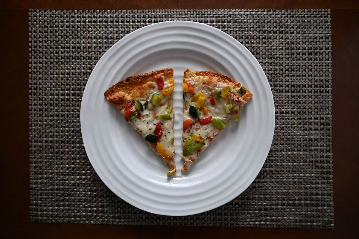 Top down image of two slices of the cauliflower crust pizza served on a white plate.