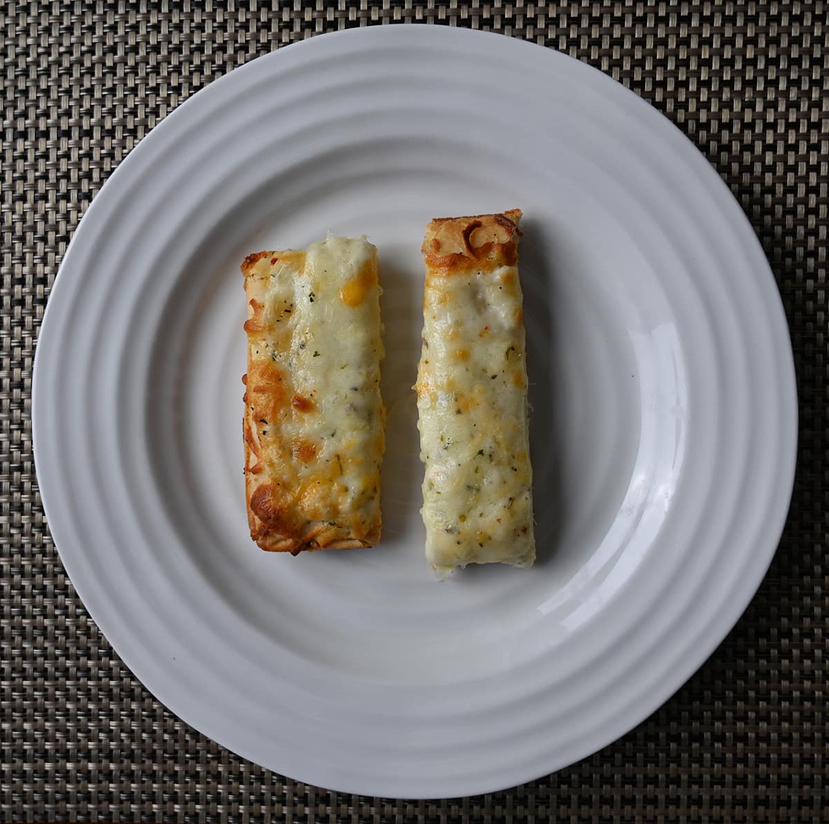 Top down image of two pieces of cheese bread served on a white plate.