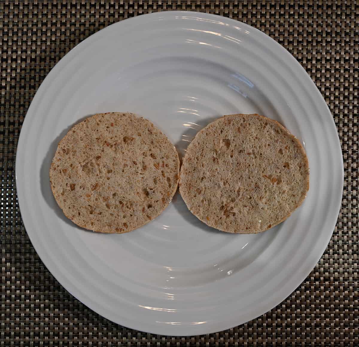 Top down image of one sandwich thin open faced without any toppings served on a white plate.