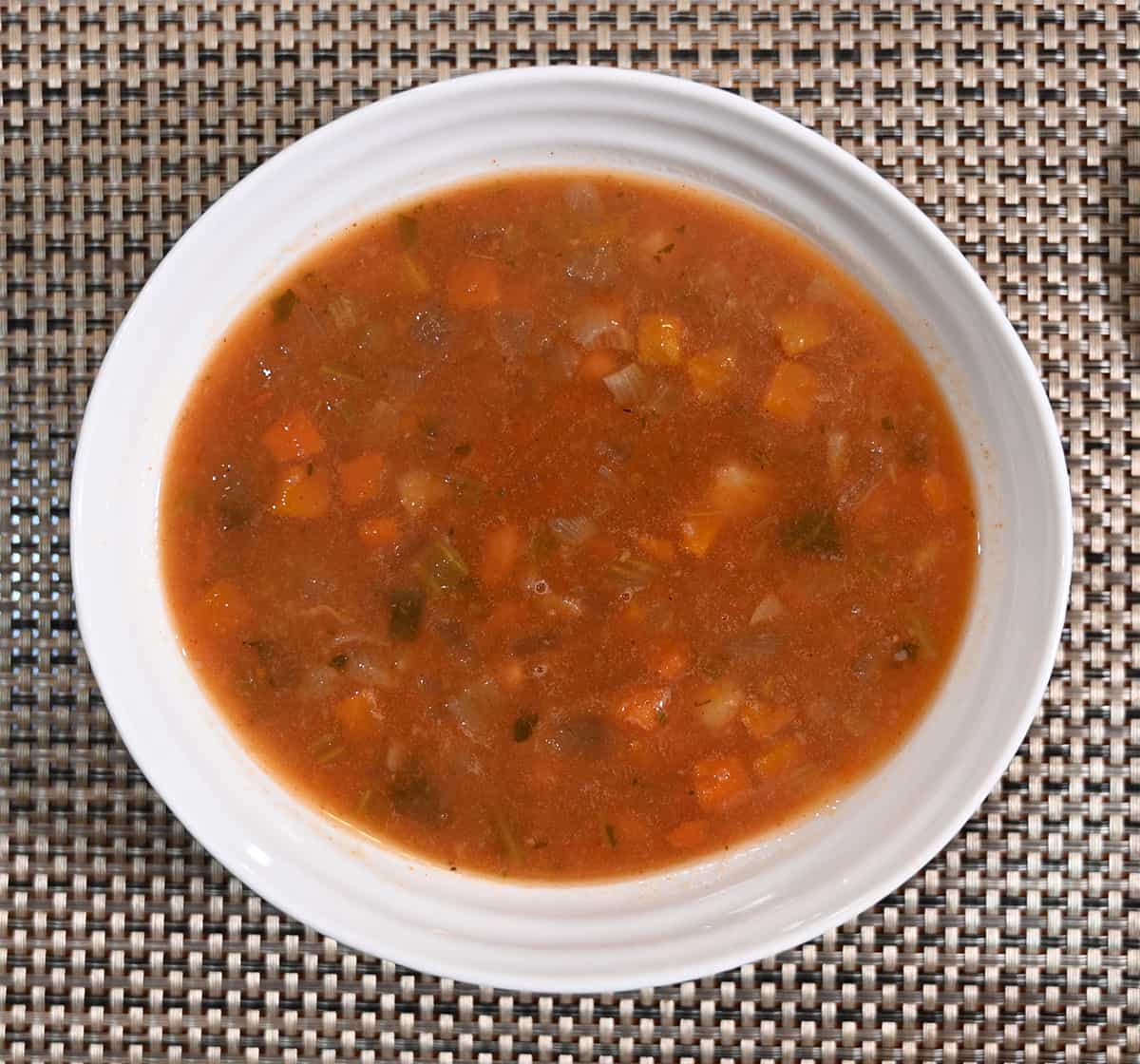 Closeup top down image of a bowl of Tuscan White Bean & Kale Soup.