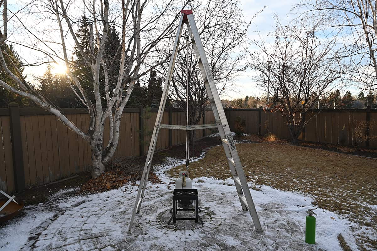 Image showing a turkey derrick setup for deep frying a turkey in a backyard on a patio.