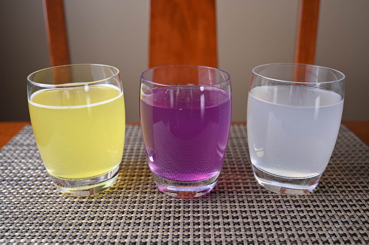 Image of three clear glasses with cove soda poured into them. There is three different colours, orange, purple and cloudy white.
