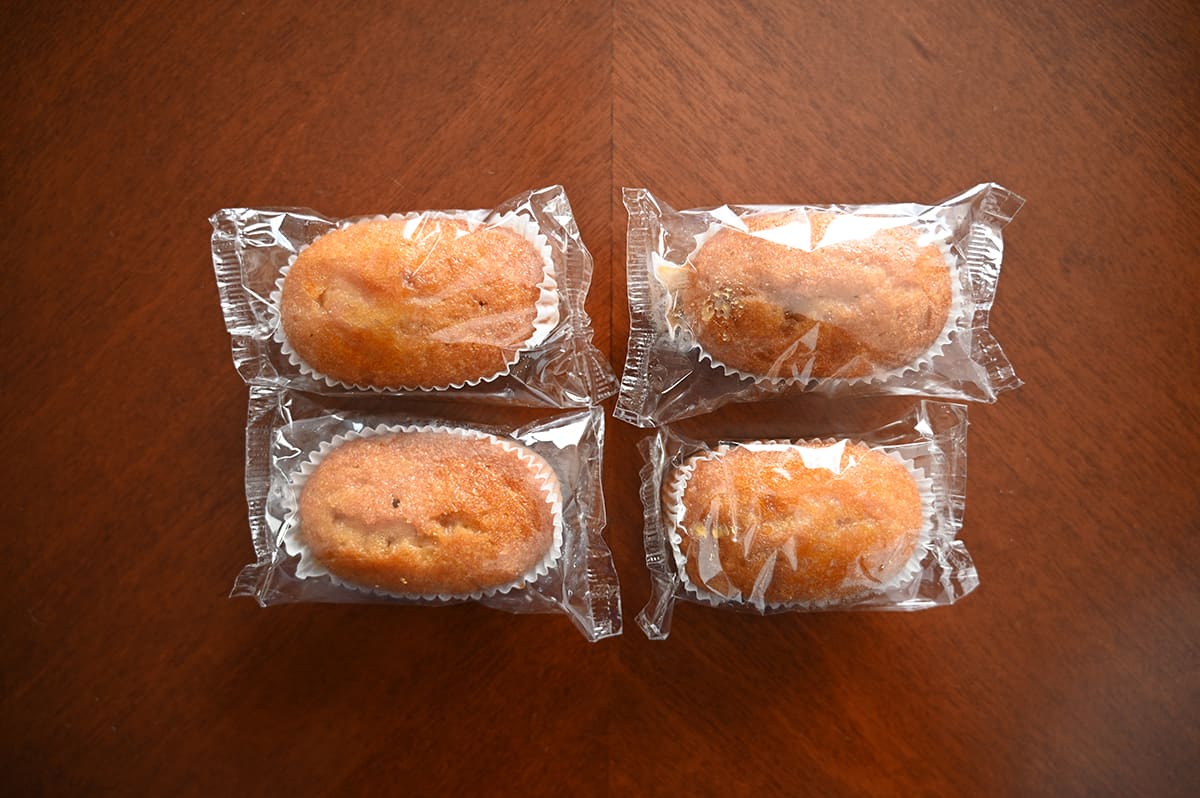 Top down image of four individually packaged muffin bites sitting on a table.