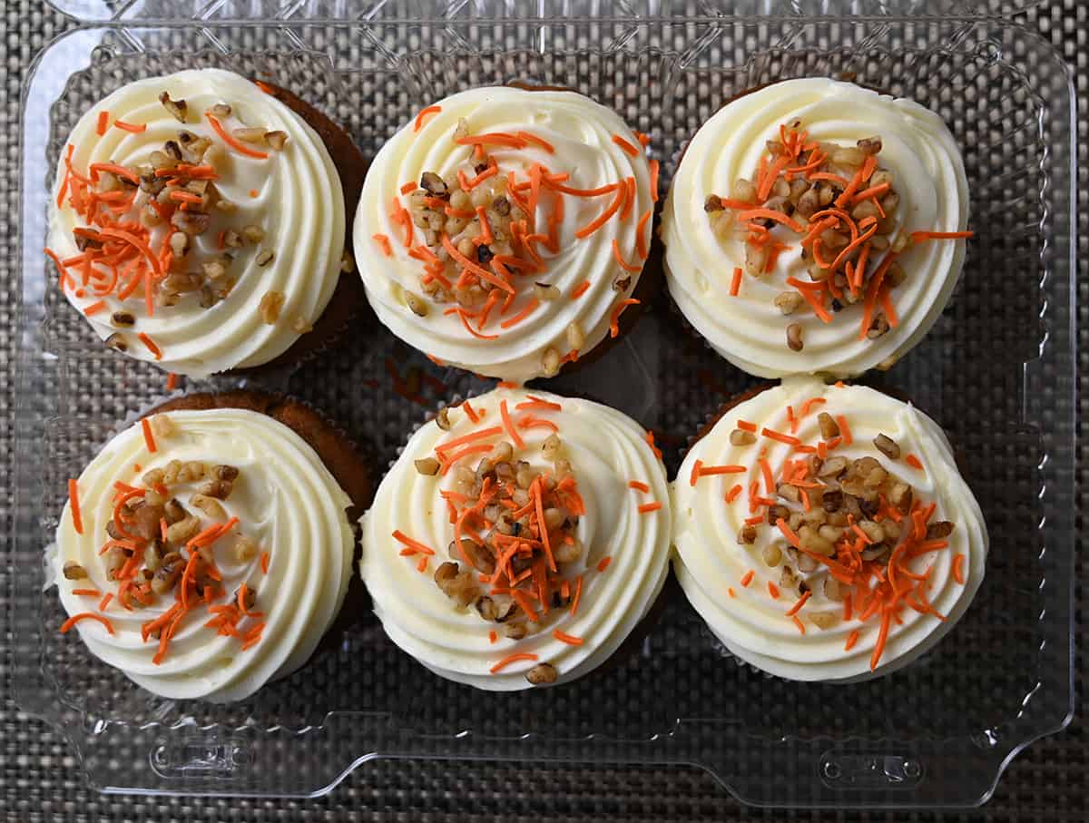 Top down image of the open container of mini cakes showing six cake tops. 