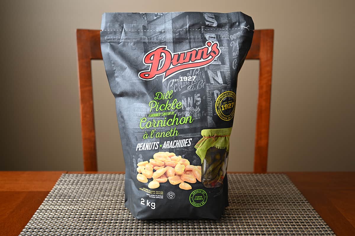 Image of the Costco Dunn's Dill Pickle Flavoured Peanuts bag sitting on a table unopened.