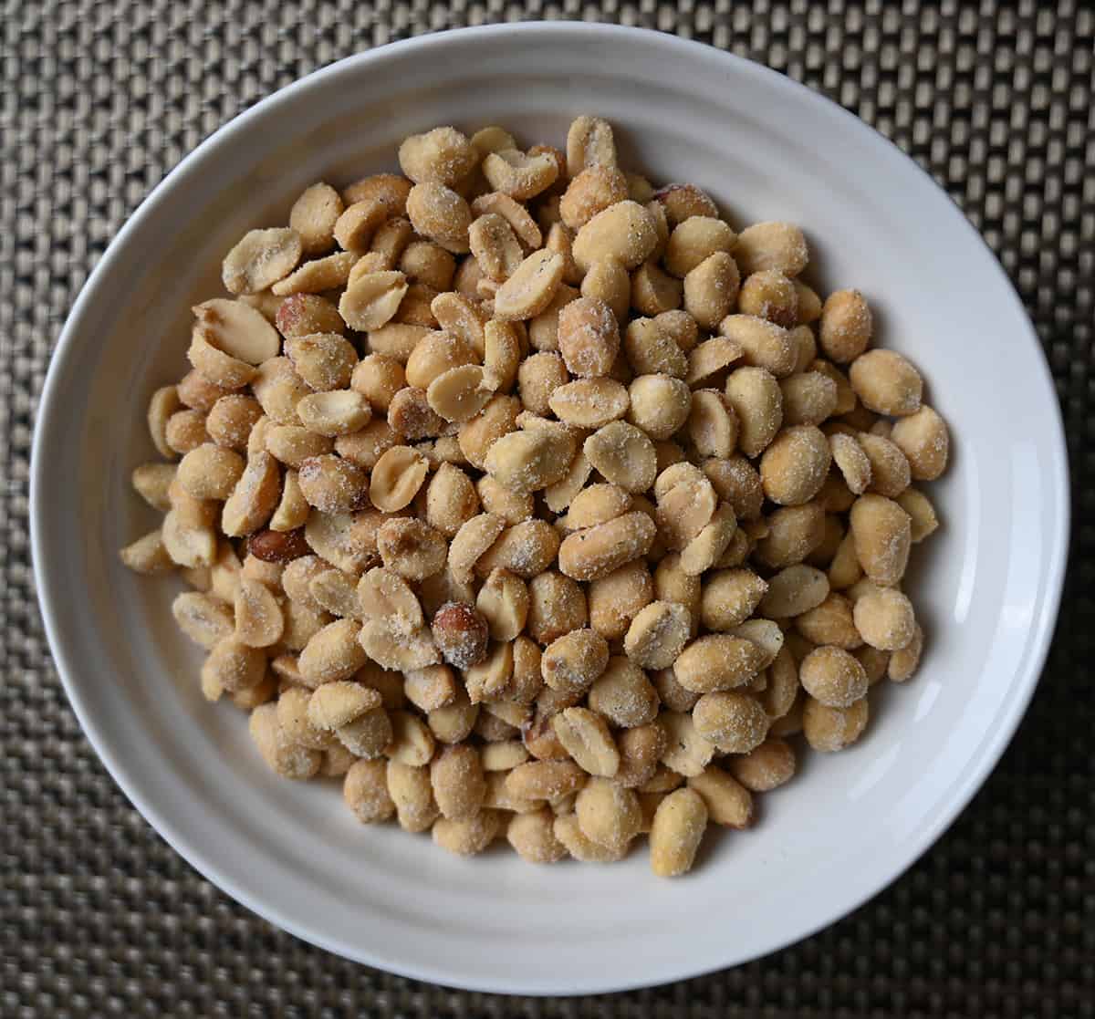 Top down image of a bowl of dill pickle peanuts.