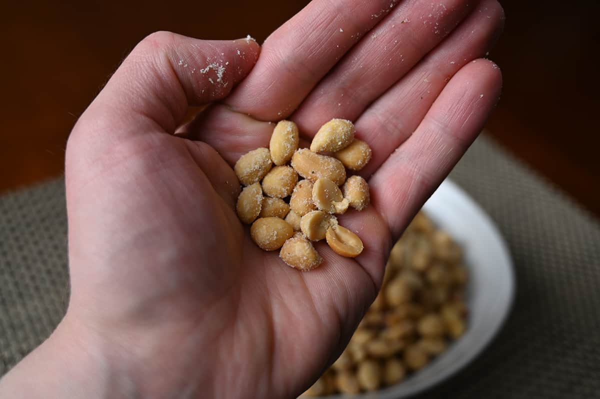 Closeup image of a hand with a palm full of peanuts close to the camera.
