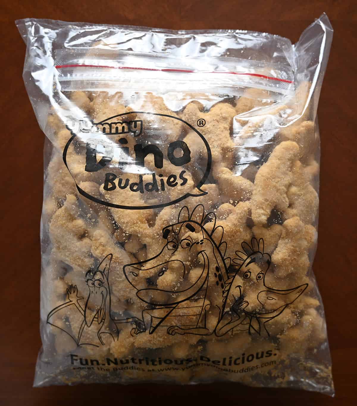 Image of a large plastic resealable bag of frozden dino nuggets.