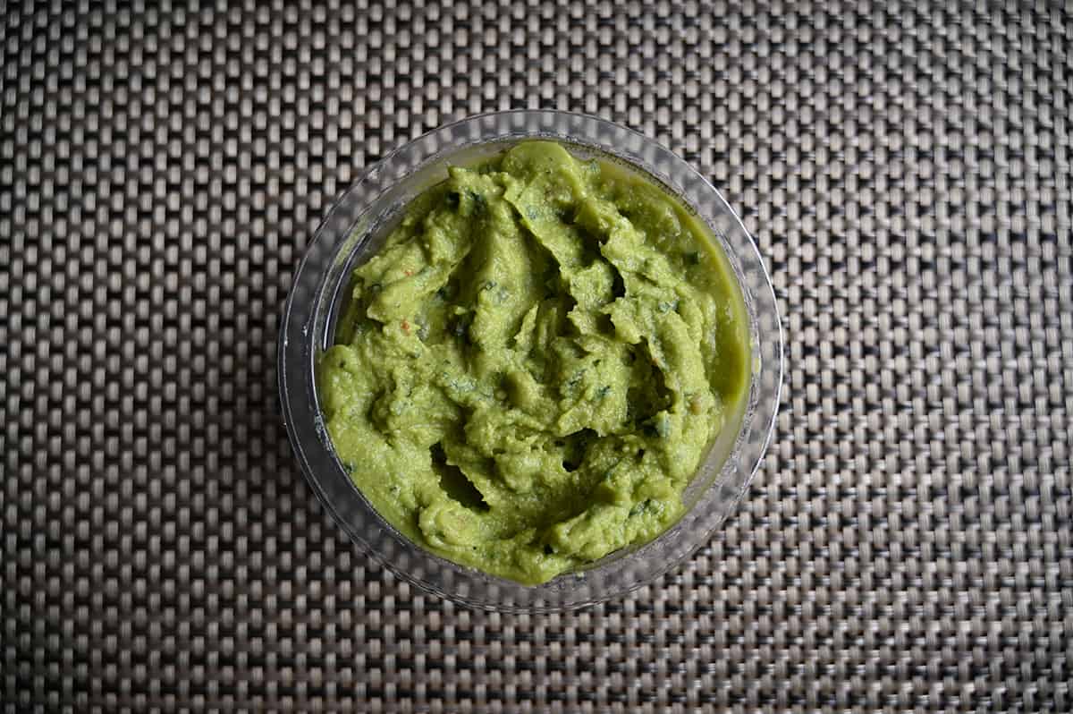 Top down image of an open container of guacamole so you can see the texture of it.