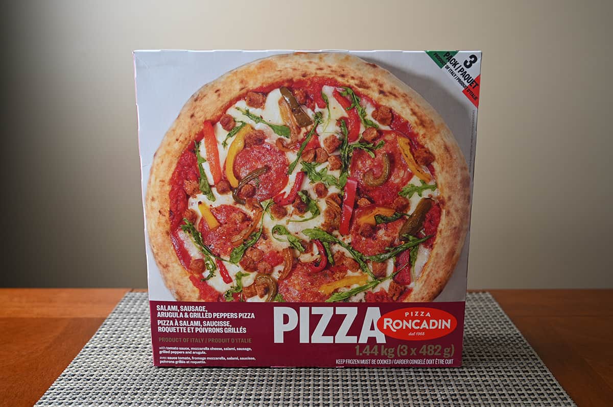 Image of an unopened Pizza Roncadin salami, sausage, arugula & grilled peppers pizza box sitting on a table.