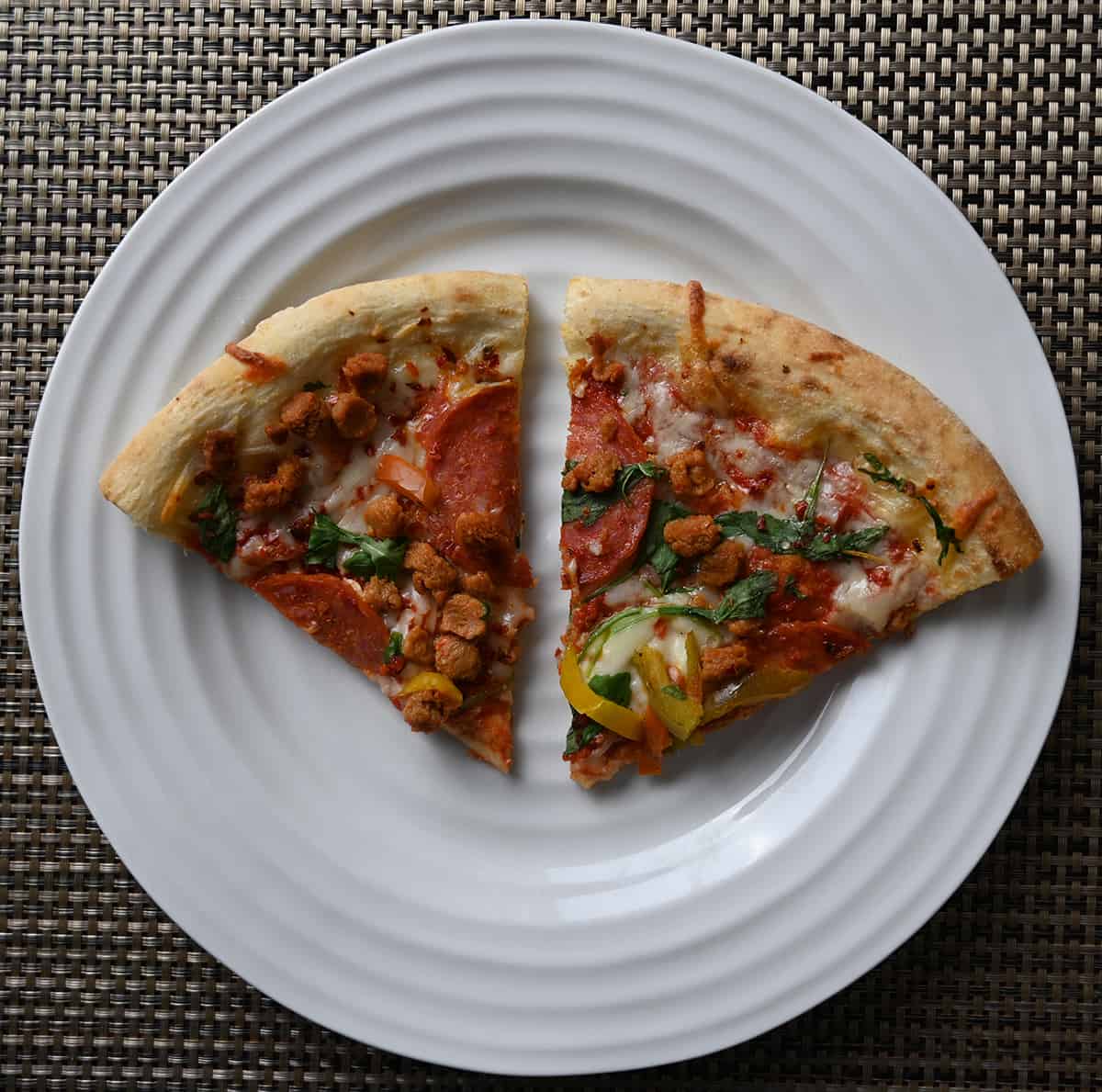 Top down image of two slices of pizza served on a white plate.