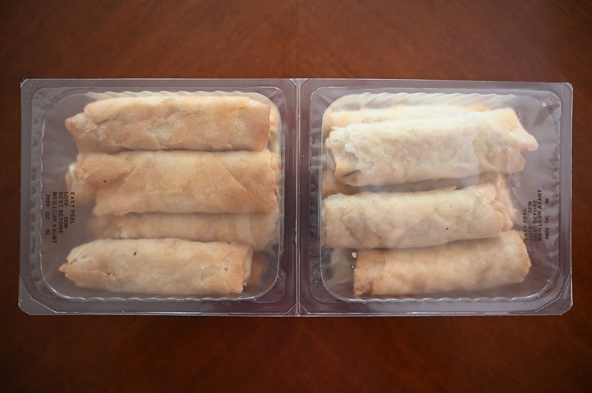 Top down image of two seperate plastic packages of spring rolls.