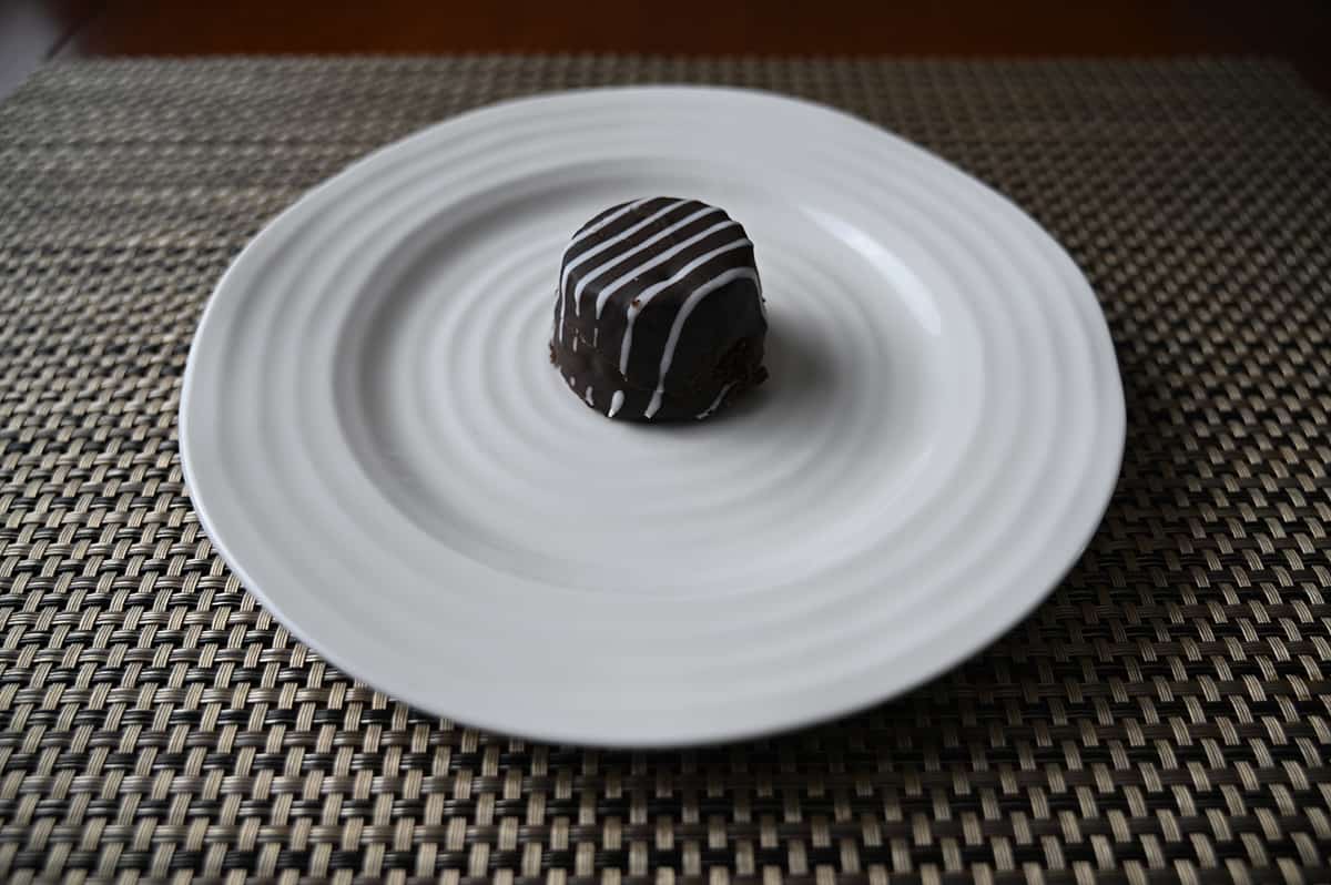 Sideview top down image of one tuxedo cake bite served on a white plate.