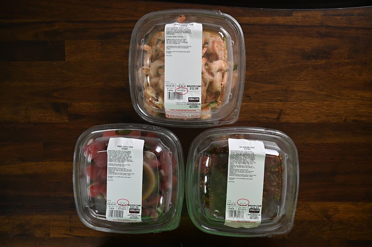Top down image of three unopened containers of Costco poke sitting on a table.