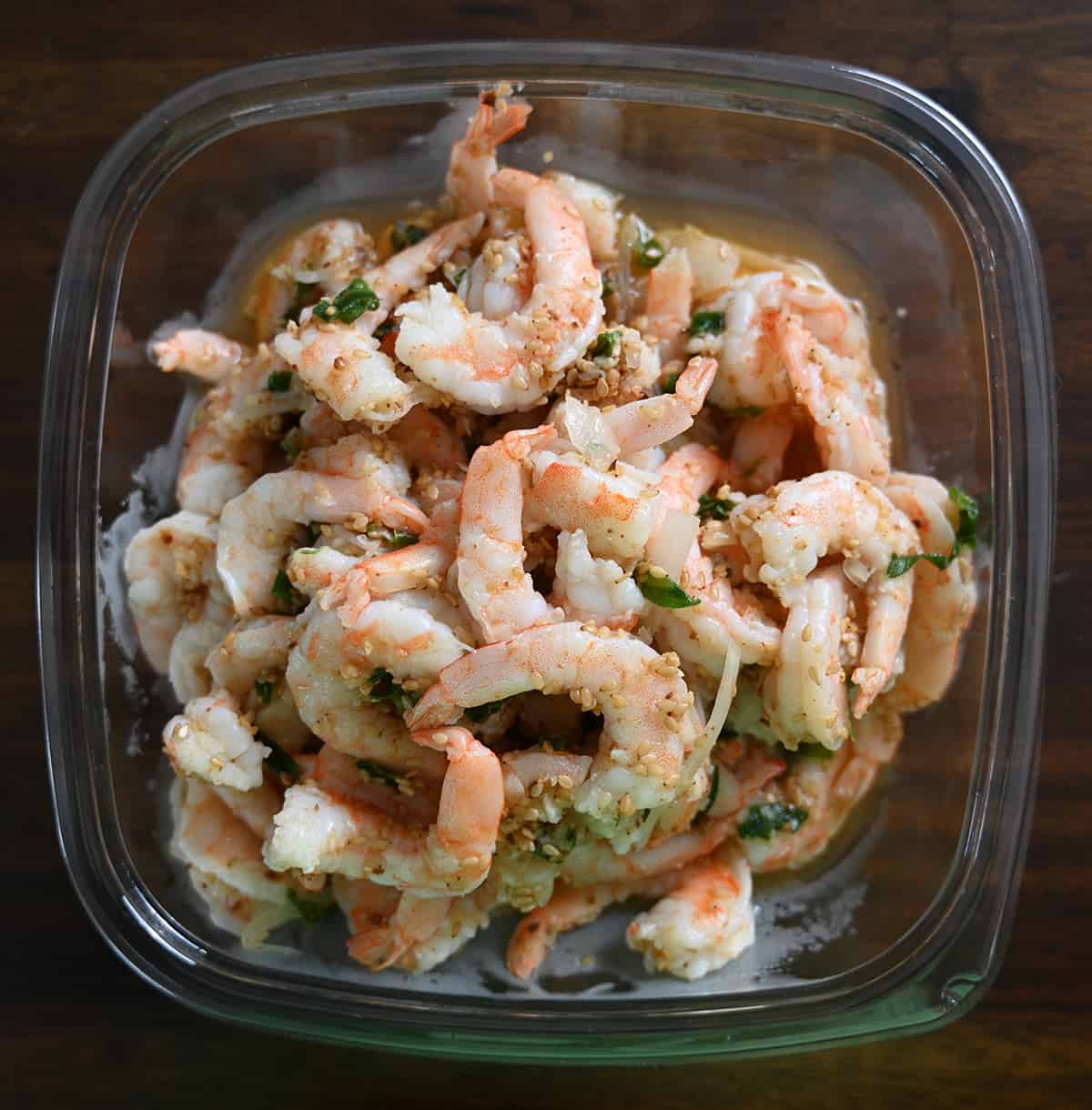 Top down image of an open container of the Garlic Shrimp Poke. There are sesame seeds covering the poke.