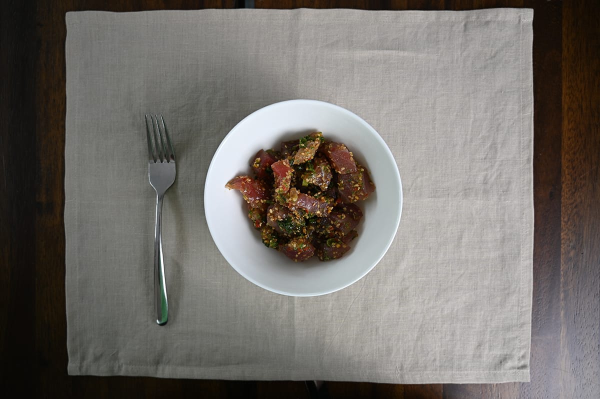 Top down image of a bowl of Ahi Wasabi Poke. There is a fork next to the bowl. 