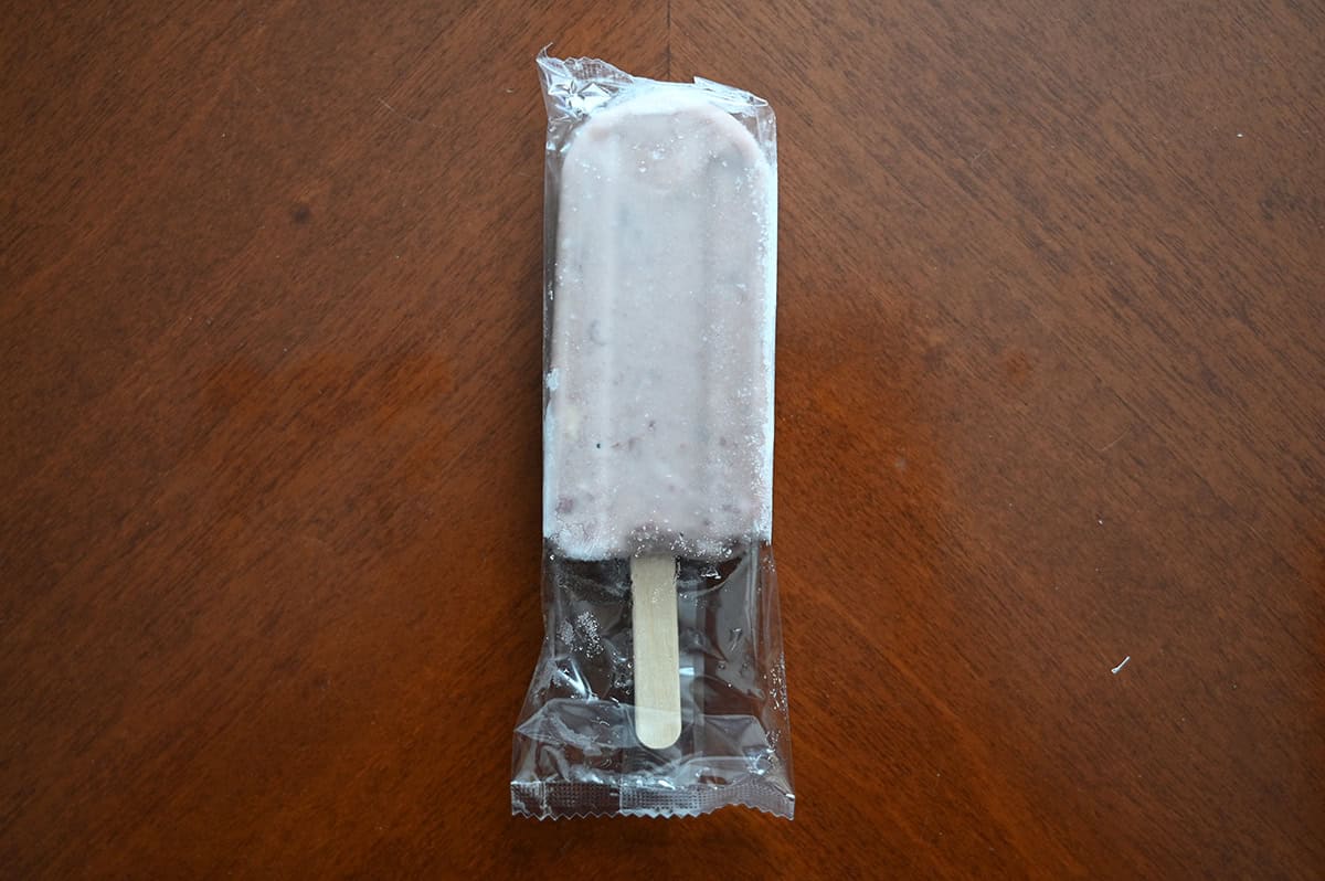 Top down image of one frozen Azuki bar in the clear plastic wrapper, sitting on a table.