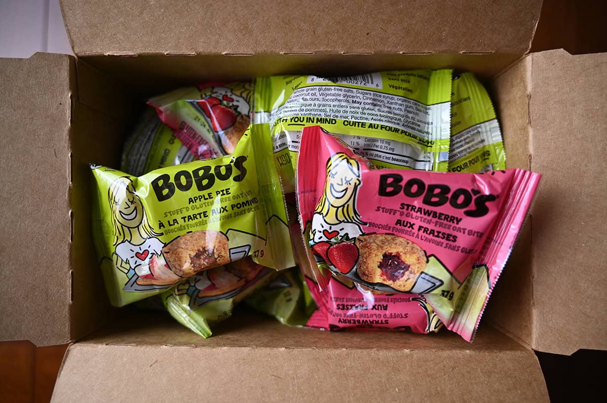 Top down image of an open box of Bobo's oat bites with two packaged oat bites in strawberry and apple sitting on the top of the box.