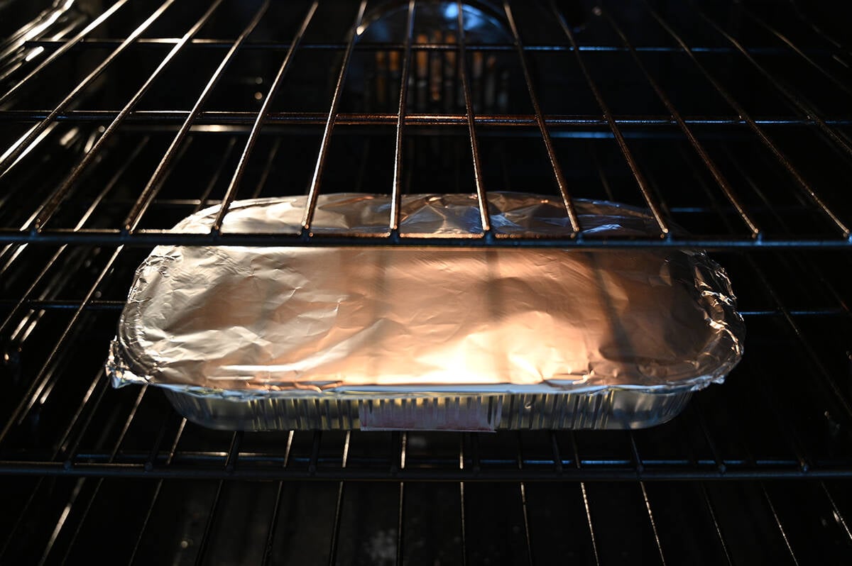Image of the jambalaya tray covered in foil sitting in an oven.