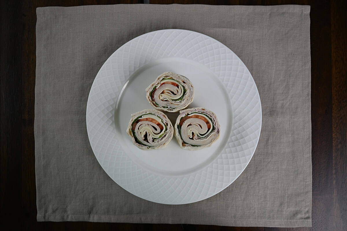 Top down image of three rolled wraps served on a white plate. 