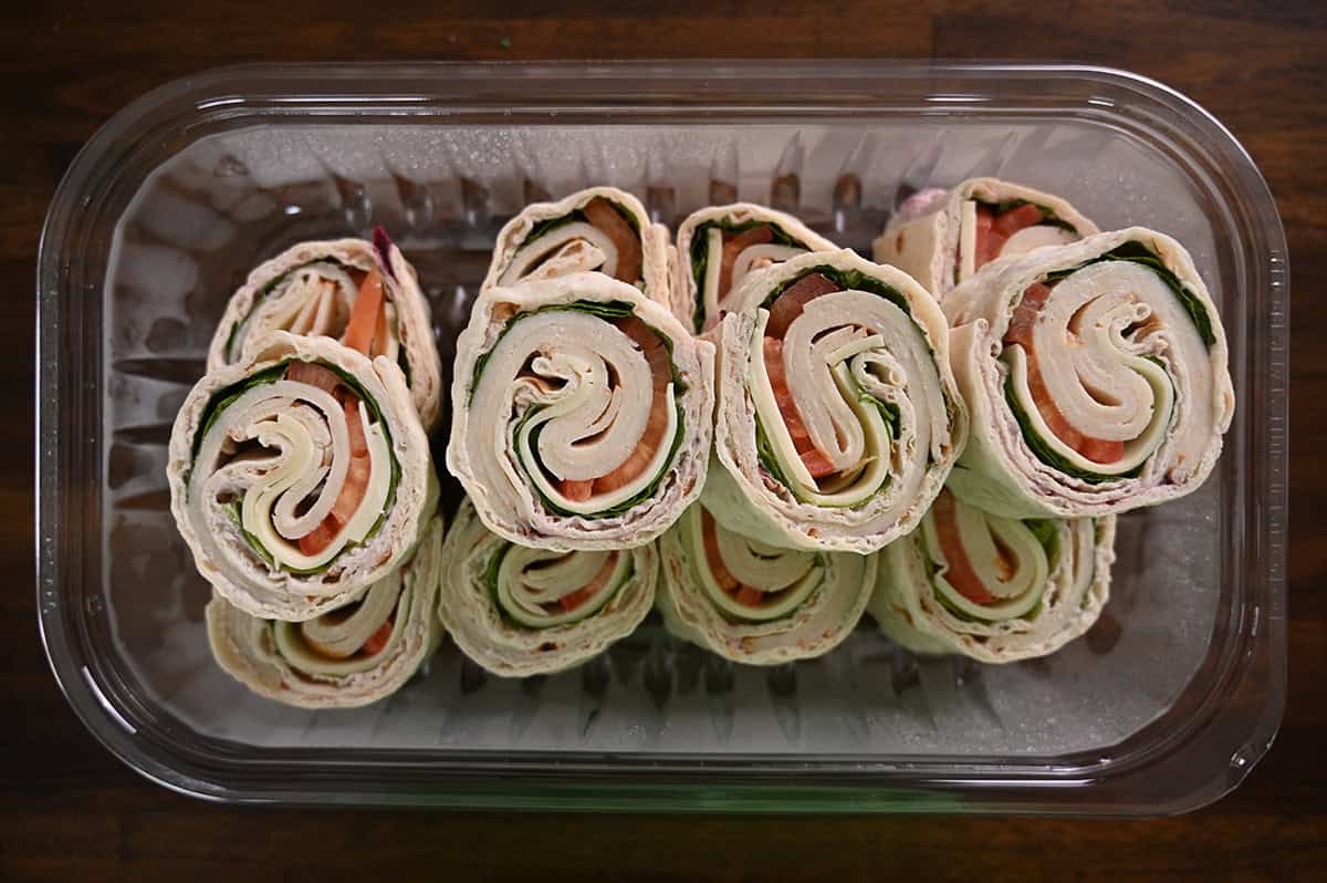 Top down image of an open tray of Costco roll ups. There are 12 pinwheels in the container.