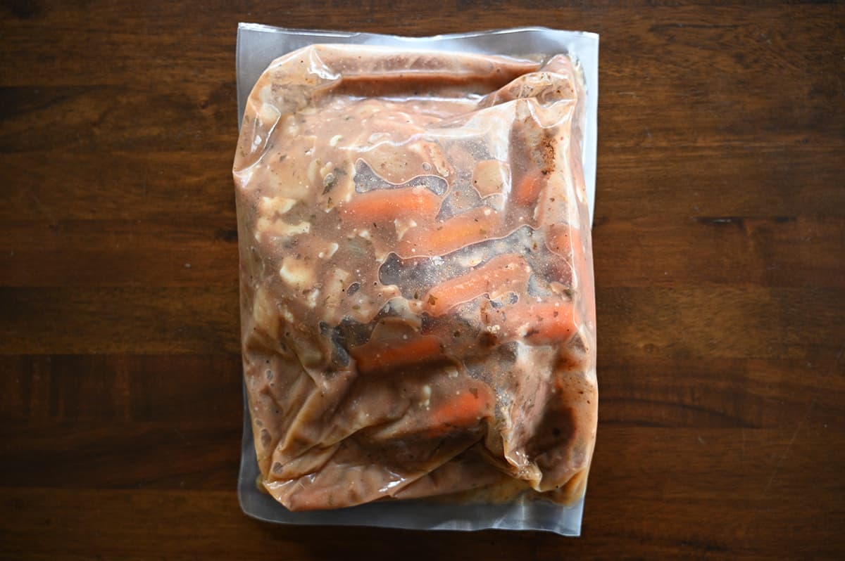 Top down image of a plastic bag of stew unopened sitting on a table.
