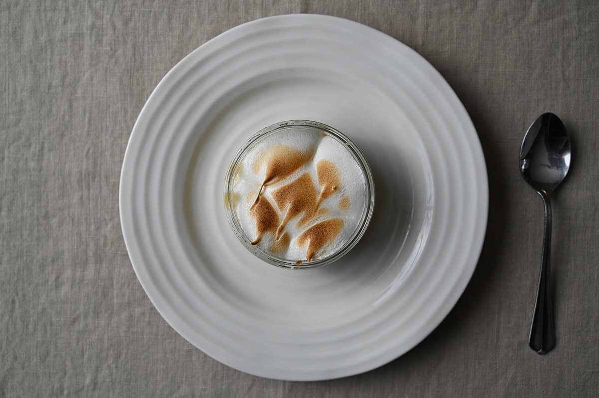 Top down image of one lemon meringue pie sitting on a table, showing the toasted meringue topping.