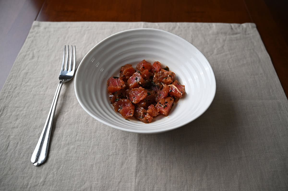 Side view close up image of a bowl of tuna poke sitting on a table.