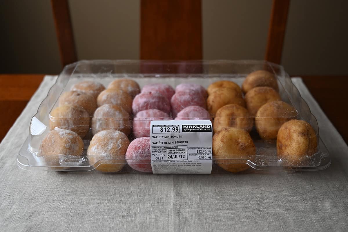 Image of the Costco Kirkland Signature Variety Mini Donuts container sitting on a table unopened.