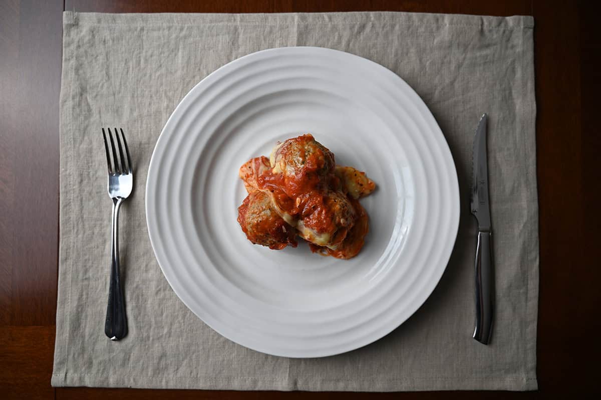 Top down image of cooked meatballs on a white plate. 