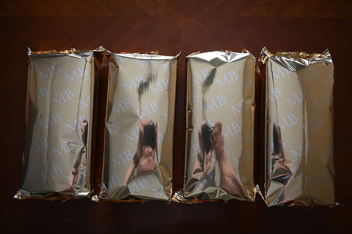 Image of four unopened packages of almond crisps sitting on a table.