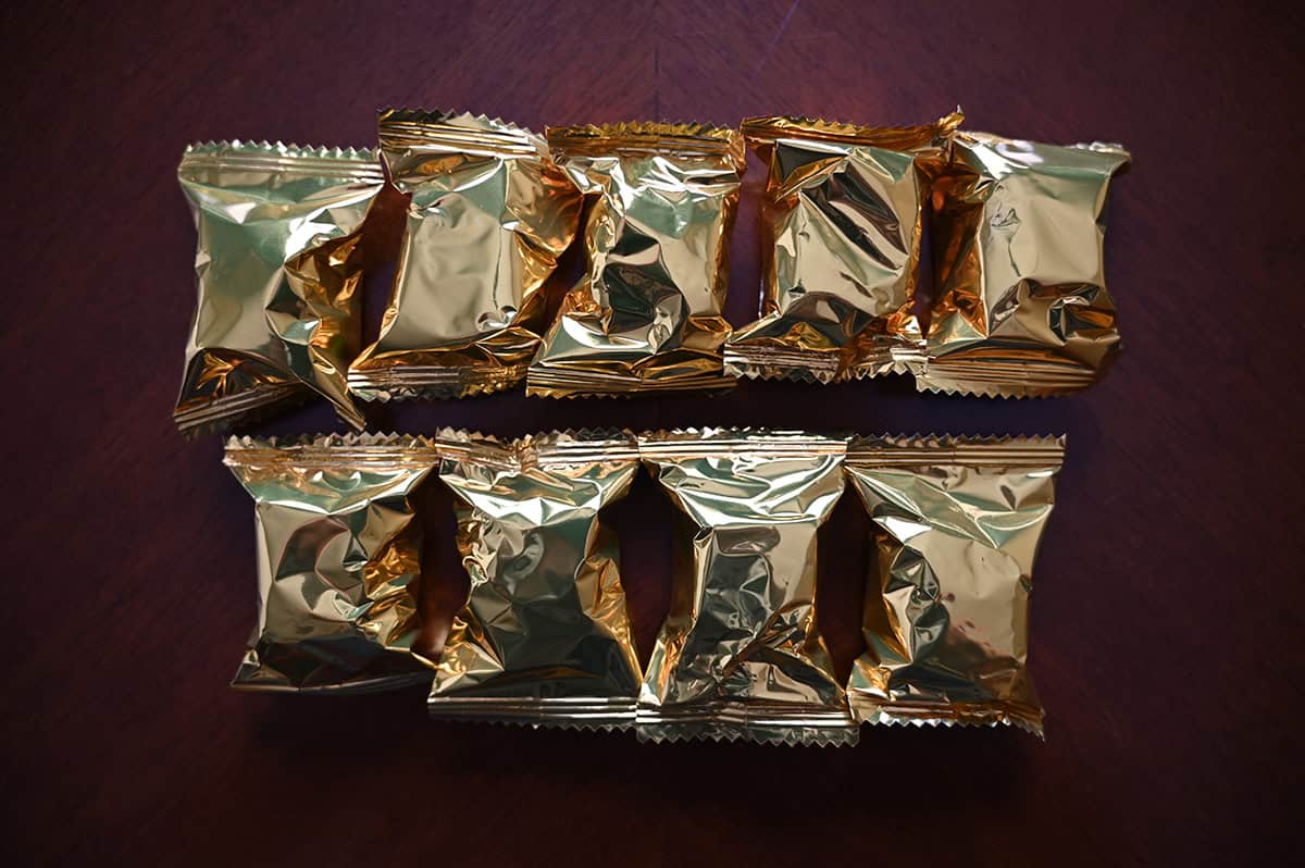 Image of nine unopened individually wrapped chocolate truffles sitting on a table. 