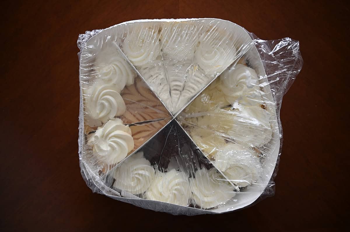 Image of the Costco Cheesecake Factory frozen cheesecake wrapped in plastic with four sections on a table.