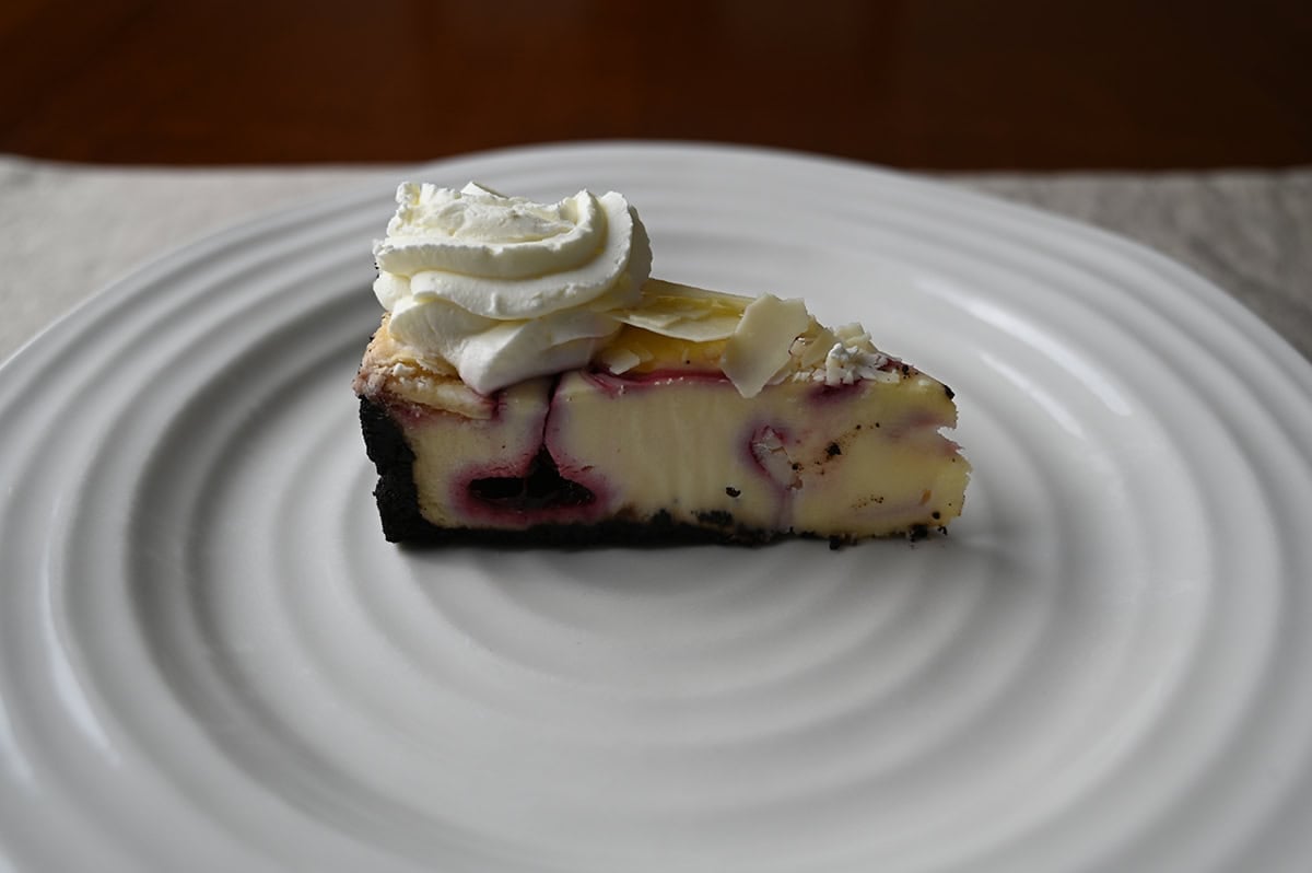 Image of one slice of white chocolate truffle raspberry cheesecake served on a plate.