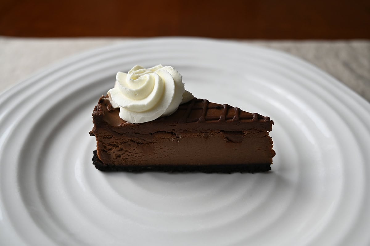 Image of one slice of double chocolate cheesecake served on a white plate.
