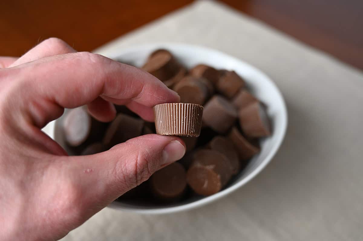 Image of a hand holding one cookie butter cup close to the camera so you can see the size of them.
