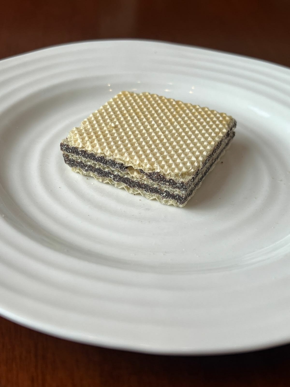 Sideview image of one wafer served on a white plate.