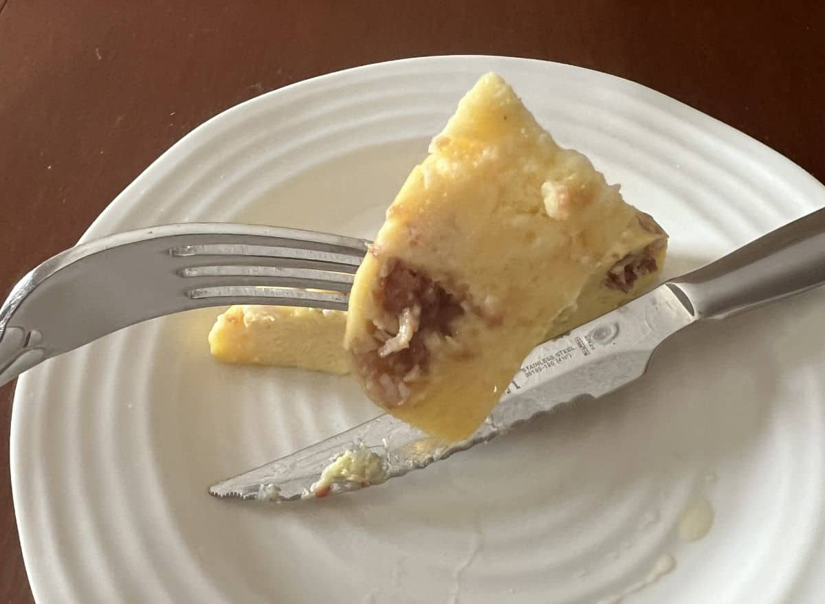 Image of  a fork with a bite of the bacon & cheese egg bite on it.